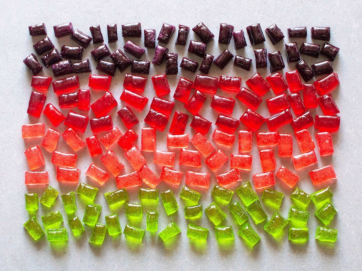 Rows of homemade hard candies in purple, red, pink and green, arranged by color